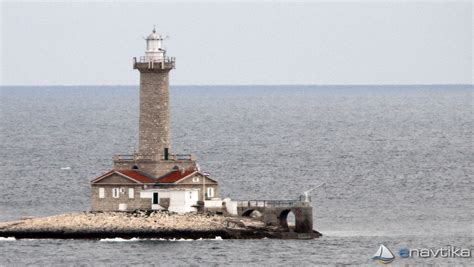Svetilnik na otočku Porer, ki ponosno stoji nad modrim morjem.