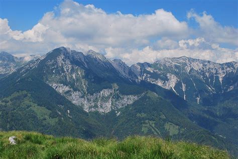 Panoramski razgled na slovenske Alpe s travnatim pobočjem