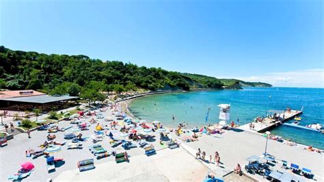 Peščena plaža Simonov zaliv z ležalniki in sončniki