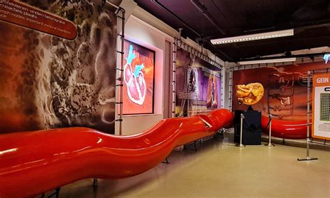 Zunanji pogled na Corpus Museum z velikansko oranžno skulpturo človeka