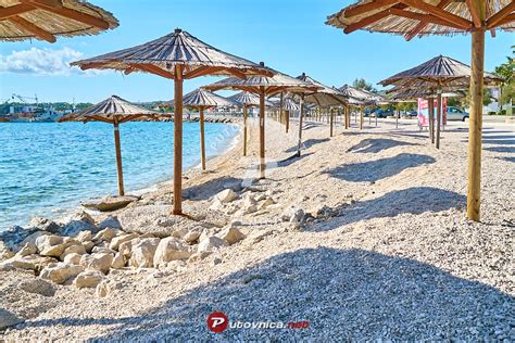 Prodnata plaža Jadro z modrim morjem in sončniki