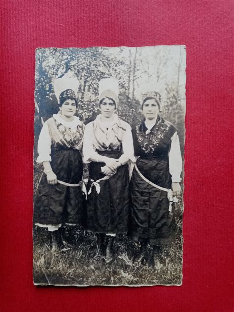 Fotografija ženske v tradicionalni noši, ki suši perilo