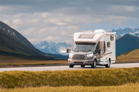 Avtodom na postajališču v Mojstrani z zaledjem Julijskih Alp