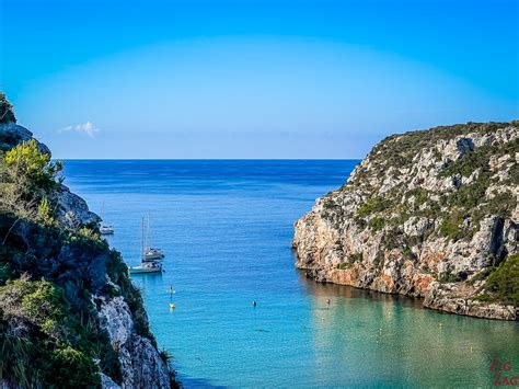Pogled na plažo Cala en Porter z belim peskom in turkiznim morjem