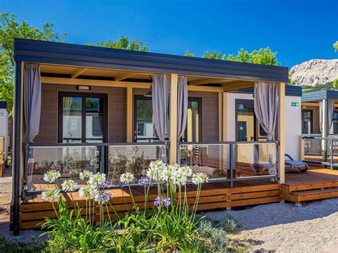 Družina uživa na terasi mobilne hišice ob morju