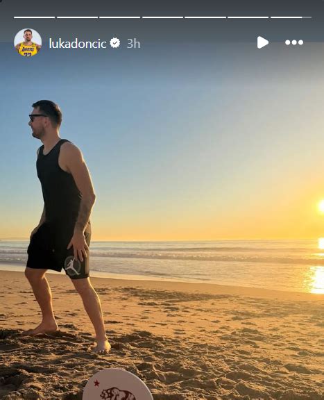 Romantični par na plaži ob sončnem zahodu