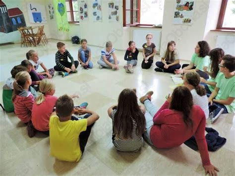 Otroci, ki sedijo v krogu in igrajo igro