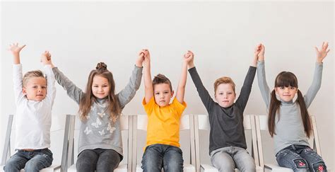 Otroci, ki počepnejo in vstajajo v ritmu igre