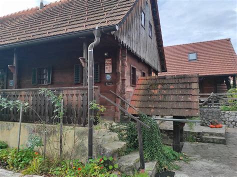 Pogled na Škrabčevo domačijo s cvetnim travnikom v ospredju