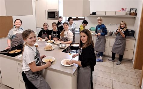 Mladi kuharji pripravljajo jedi v sodobni kuhinji