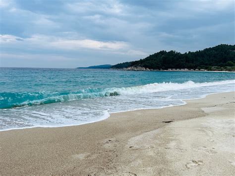 Slika plaže z drobnim peskom in turkiznim morjem