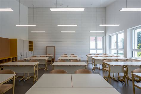 Notranjost stare šolske učilnice s klopmi in tablo