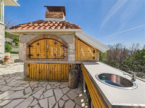 Podeželska hiša z urejenim vrtom, ki ponazarja kmečki turizem