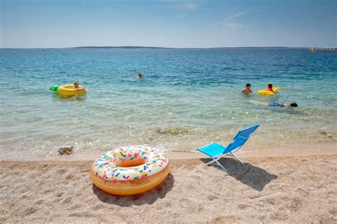Prodnata plaža v Fažani z družinami, ki uživajo v morju