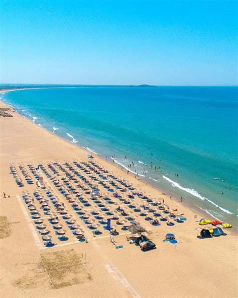 Fotografija družine, ki uživa na plaži pred hotelom Neptun