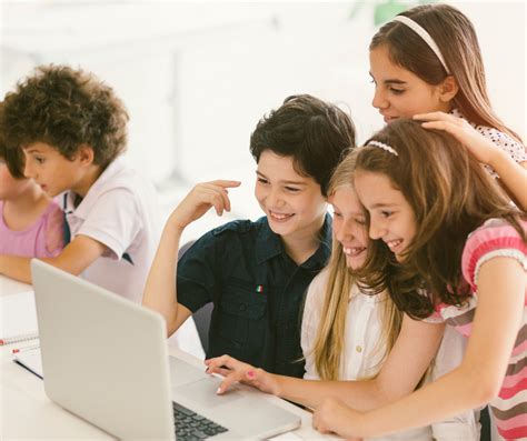 Skupina otrok se uči osnovnih zavojev na blagi strmini pod nadzorom inštruktorja