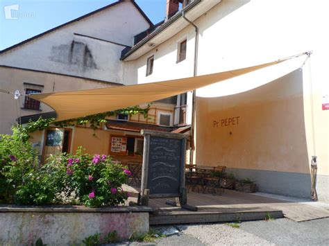 Terasa gostilne s posedajočimi gosti pod trto