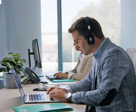 Oseba, ki dela na računalniku in se nasmehne stranki