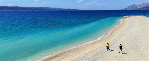 Pogled na plažo Ikovac v Baški Vodi z borovci in prodnatim obrežjem